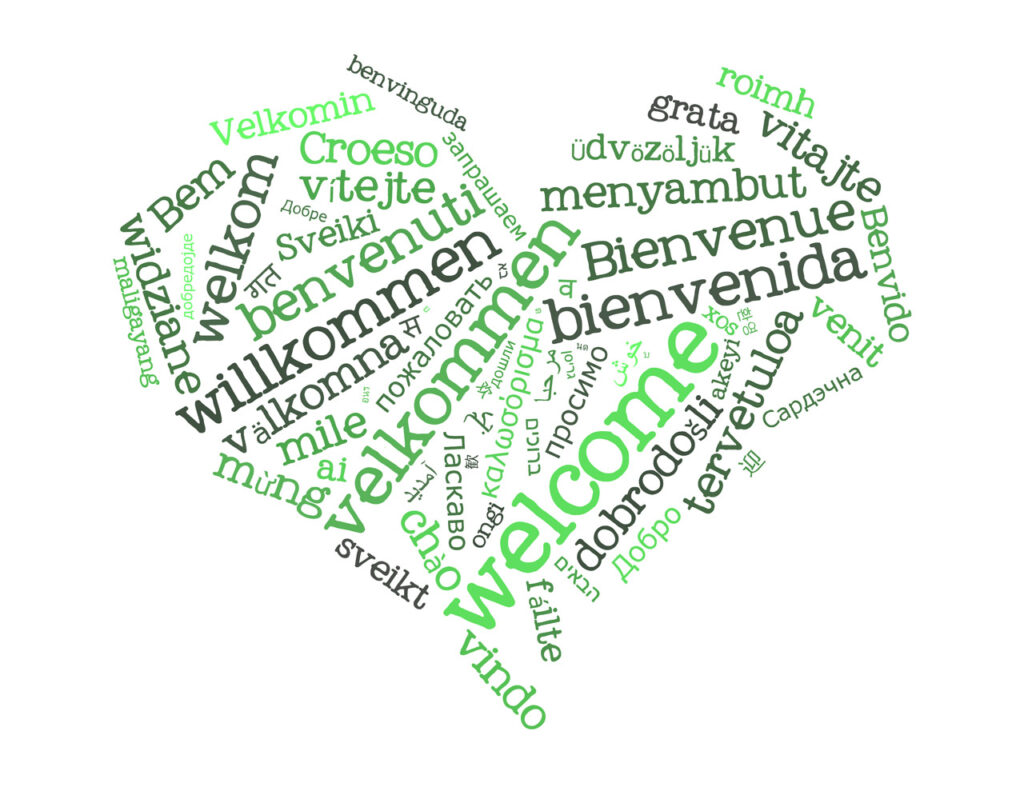 Herz aus "Willkommen" Schriftzügen in verschiedenen Sprachen und Fonts. Alles in versch. Grüntönen gehalten.